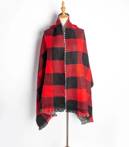 Détail de l'écharpe à carreaux rouges et noirs montrant le tissu doux et les franges