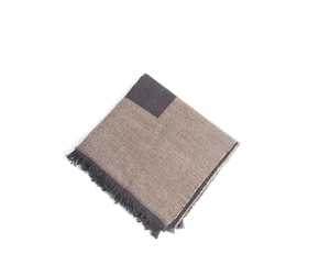 Close-up of thick geometric checkered scarf featuring fine fringe and soft texture
