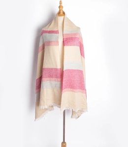 Détail d'un châle à carreaux beige rose et gris avec tissage chevrons et franges blanches