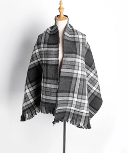 Détail d'une écharpe à carreaux gris avec franges douces et textile tissé d'hiver