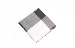 Détail du motif à carreaux doux avec des bords à franges fines sur une écharpe d'hiver
