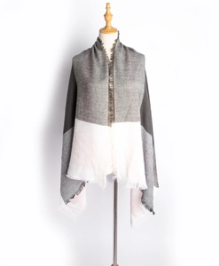 Détail d'un châle d'hiver doux avec motif rayé gris et blanc et bords à franges brutes