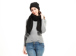 Detail von schwarzem Strickmützen-Set mit Schal und grauen Kunstfell-Bommeln für Winter