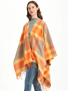 Detail of the orange plaid shawl featuring fringe edges and a thick checkered woven pattern