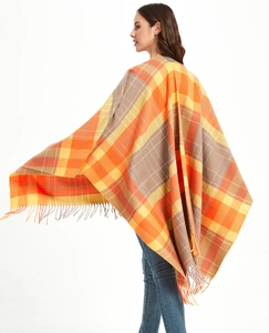 Detail of vibrant plaid shawl with fringe hem in orange and yellow checkered pattern