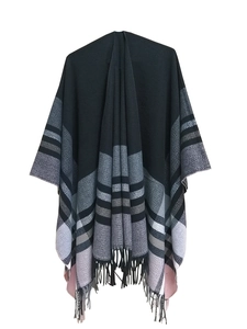 Detail of soft knit texture and fringe hem on grey and pink plaid poncho shawl