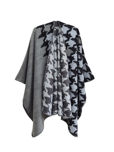 Gros plan d'un poncho en maille épaisse avec motif pied-de-poule et bordure raffinée