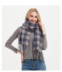 Close-up of thick plaid scarf in blue and pink with soft tassels and woven texture