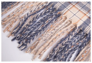 Detailed macro view of checkered scarf with long fringe tassels in blue and orange weave