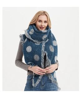 Dettaglio di una spessa sciarpa blu scuro con pois grigi e bordi a frange sottili