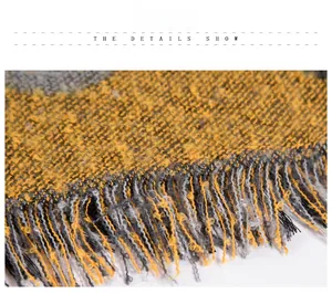 Dettaglio della sciarpa in filato boucle giallo e grigio con spessi bordi a frange