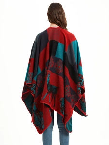 Detail of the knit poncho featuring a large llama jacquard pattern and ethnic motifs