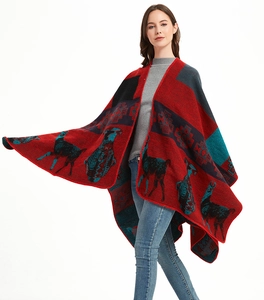 Detail of red jacquard knit poncho with alpaca motifs and geometric bohemian patterns