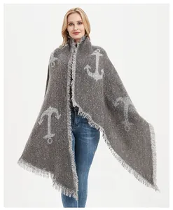 Close-up of grey knit scarf featuring white anchor patterns and fine fringe trim