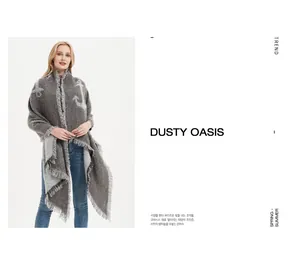 Detail of dark grey thick winter scarf with large white anchor pattern and long tassels