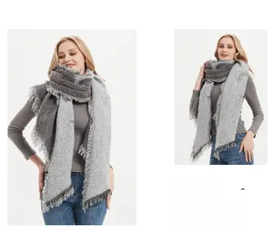 Detail of grey knitted scarf with fringe tassels and split-color textured patterns