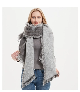 Detail of grey thick knit scarf with long tassels and soft loop yarn texture for winter