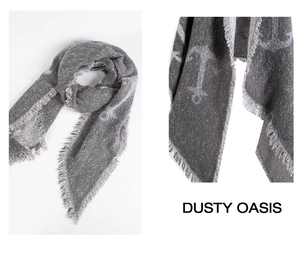Close-up of light gray knit scarf featuring white anchor patterns and fringe edge details