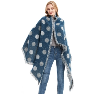 Scialle in maglia blu a pois bianchi con frange indossato da una modella donna