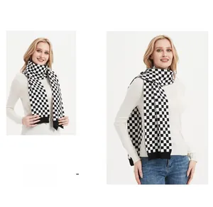 Detail of a thick black and white checkerboard knit scarf with ribbed edge and soft texture