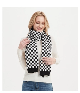 Detailed texture of black and white checkerboard knit scarf with ribbed hem finish