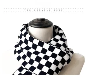 Detail showing the black and white checkerboard knit pattern on a thick winter scarf