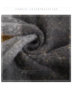 Détail du tissu d'écharpe gris doux avec des reflets dorés et une texture laineuse