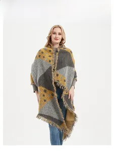 Gros plan sur un châle en tricot géométrique avec des touches jaune moutarde