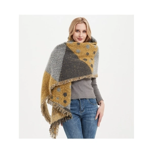 Détail de l'écharpe en tricot montrant des motifs géométriques et des franges