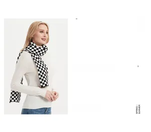 Close-up of black and white checkerboard knit scarf paired with a white turtleneck sweater