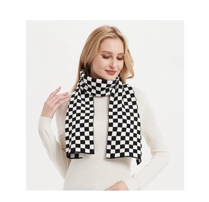 Detail of a thick black and white checkerboard knit scarf wrapped around the neck