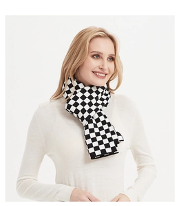 Detailed knit texture of the black and white checkerboard scarf on a female model