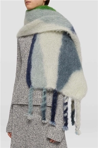 Close-up of knit scarf featuring thick twisted tassels and vibrant color-block patterns