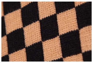 Macro view of checkered knit texture showing dense black and tan woven fibers