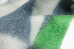 Macro detail of thick winter scarf showing soft mohair texture and grey green stripe pattern