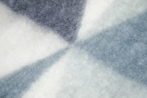 Macro view of blue and white thick knitted winter scarf with braided texture