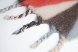 Close-up of thick twisted tassels and soft wool-like texture on multi-color striped scarf