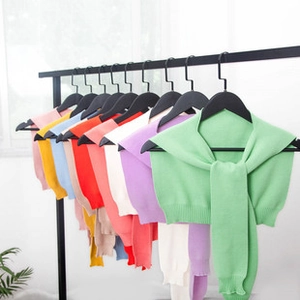 Detail of colorful knitted shawl collars with decorative ties and ribbed hem finish