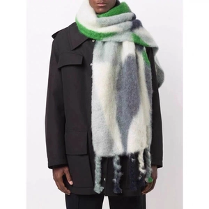 Thick winter scarf with green and grey color blocking and chunky tassels on model