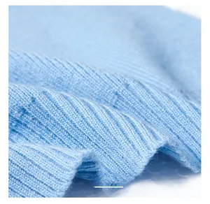 Detailed close-up of light blue ribbed knit texture and premium hem finish on shawl