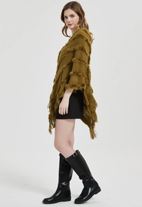 Detail of olive green knit poncho with horizontal plush stripes and long fringe tassels