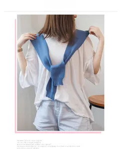 Close-up of sky blue knitted shawl with ribbed edges worn over a white casual shirt