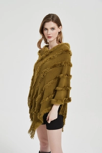 Detail of olive green knit poncho featuring textured plush stripes and long fringe tassels