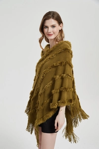 Close-up of olive green knit shawl featuring faux fur trim and tassel fringe detail
