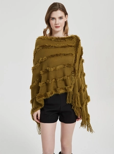 Detail of olive green knit poncho featuring plush faux fur stripes and long tassel fringe