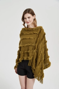 Close-up of mustard green knit shawl featuring tiered faux fur stripes and tassel fringe