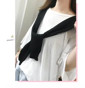 Detail of a black knitted fake collar shawl knotted over a white t-shirt for women