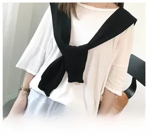 Detail of black knitted shawl layered over a white t-shirt for a minimalist Korean style