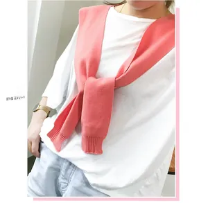 Detail of pink knitted shawl collar with ribbed edges over a white shirt for layering