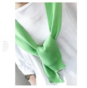 Detail of vibrant green ribbed knit shawl accessory styled over a white t-shirt
